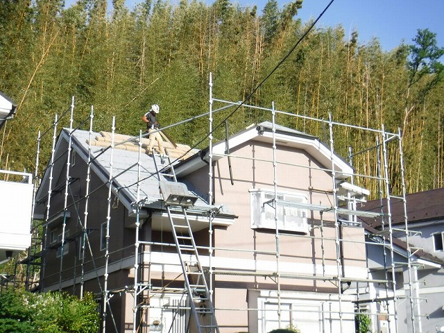 防水シートと板金張り付けている家の全景
