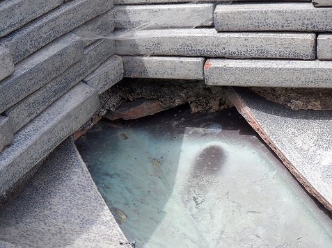 棟瓦の下の漆喰が取れて粘土が流れてる