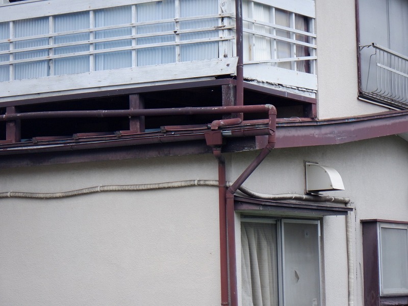 木が傷んでいるベランダと塗装の薄れた破風板