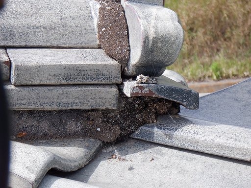 鬼瓦の下の漆喰が無く粘土が露出