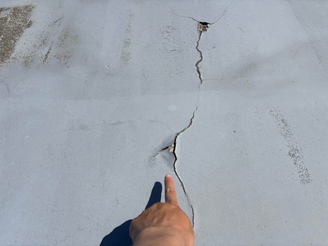 福津市の倉庫の屋根塗装のひび割れを確認