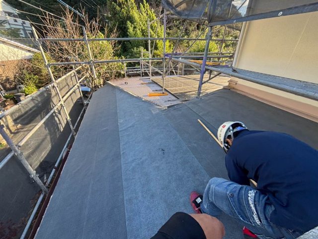 福岡市西区のカバー工事で防水シートを施工する職人
