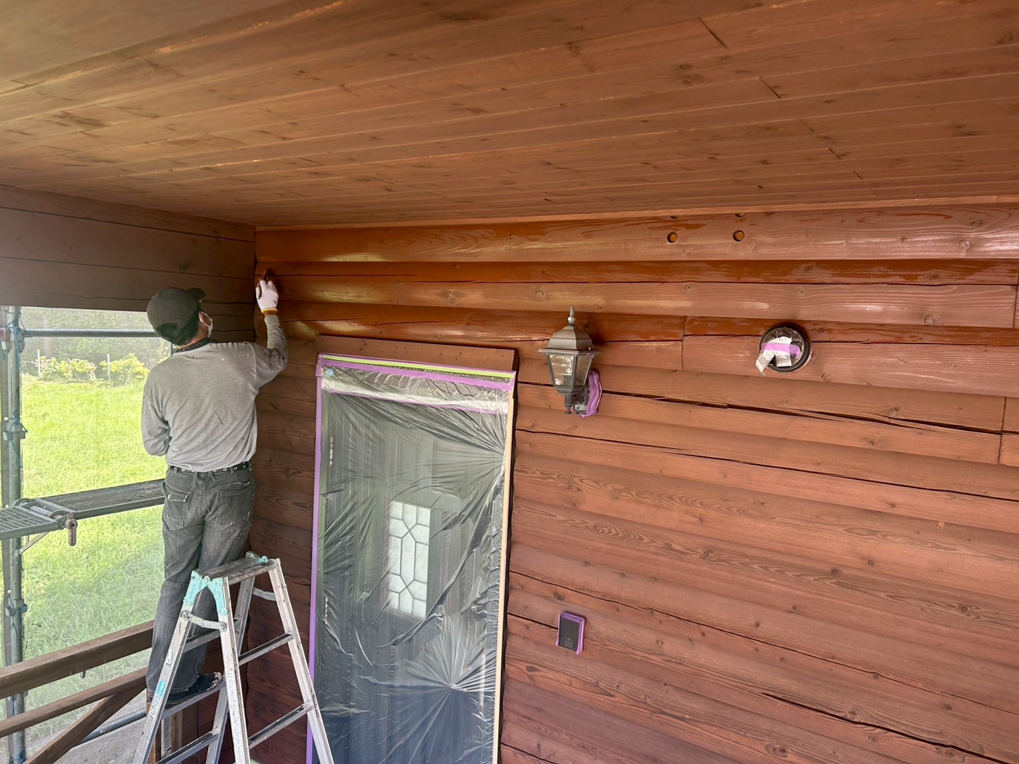 ノンロットで再塗装されたログハウスの外壁とウッドデッキ（いなべ市施工事例）