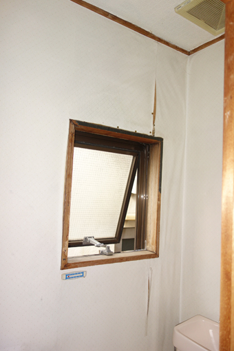 白い壁紙が剥がれかかっている。