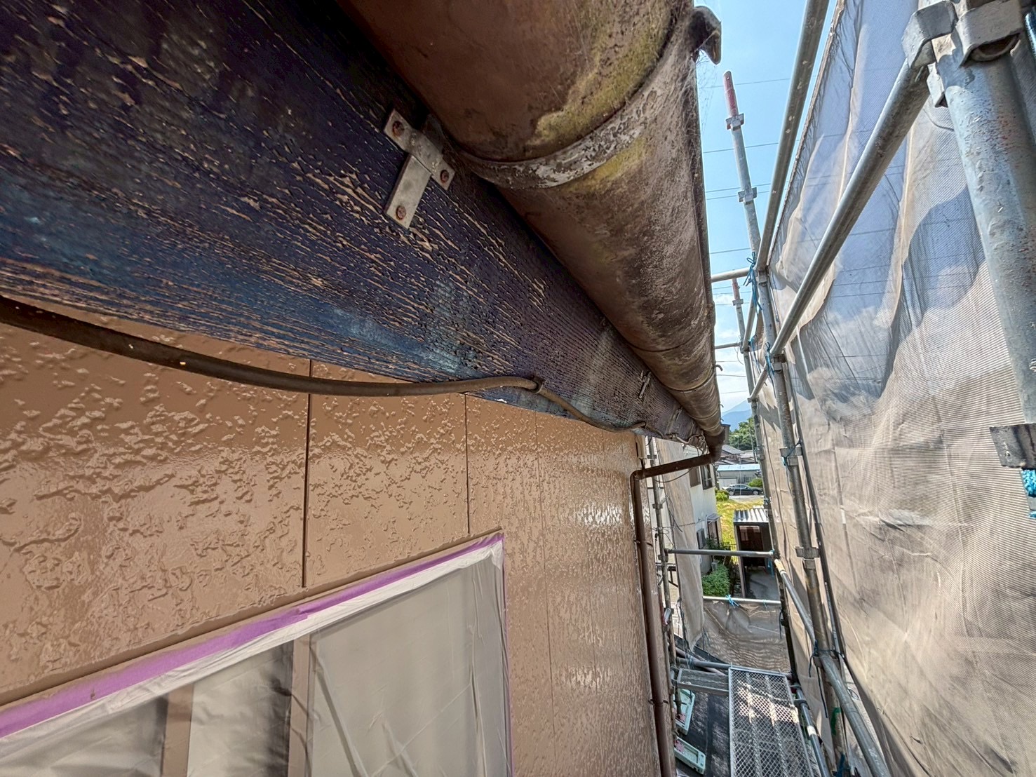 いなべ市で外壁塗装に伴い破風板に板金を取り付けている様子