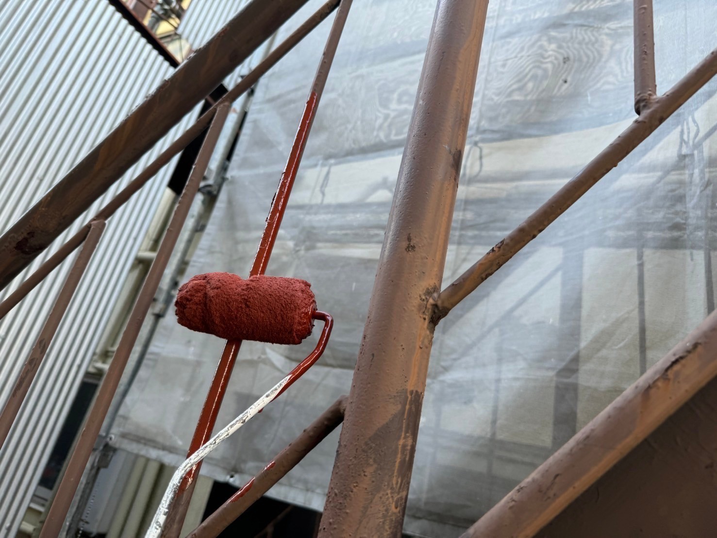 桑名市の長屋店舗の鉄骨階段の手摺塗装、一回目の塗装下塗り作業「錆止め材塗布」