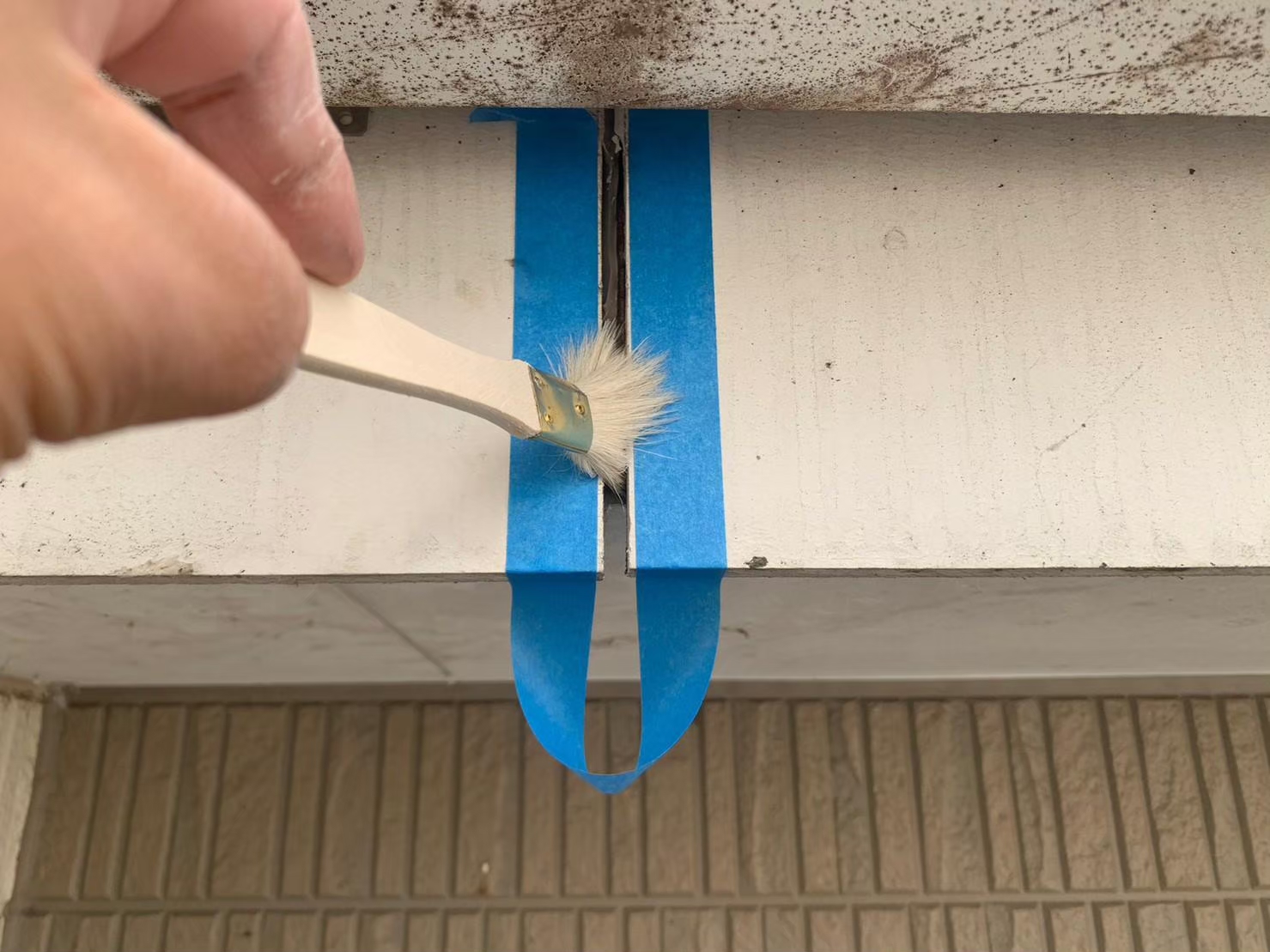 菰野町にて外壁目地「繋ぎ目」のシール打ち替え工事、シール材を打つ箇所にプライマーを塗っていきます！