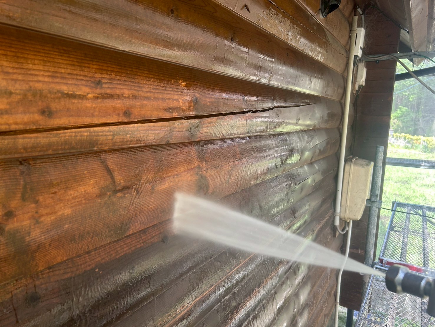 ノンロットで再塗装されたログハウスの外壁とウッドデッキ（いなべ市施工事例）