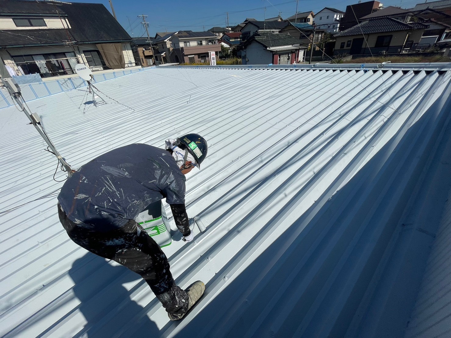 鈴鹿市の店舗折板屋根塗装中塗り作業中