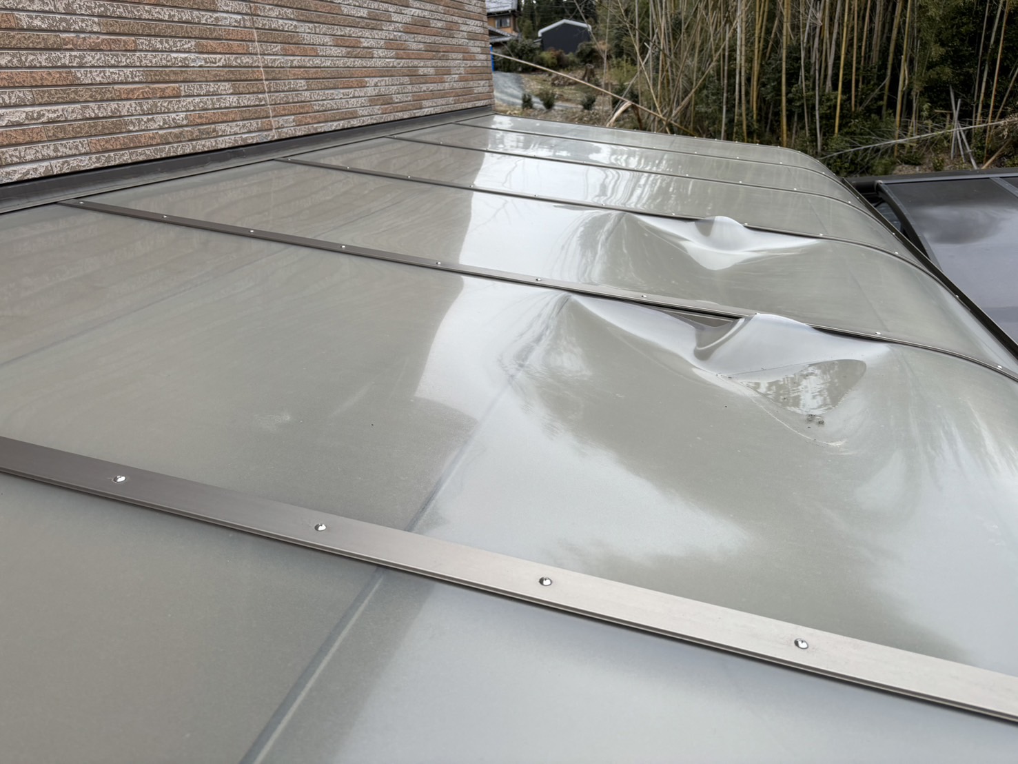 朝日町の雪の落雪で変形破損したテラス屋根