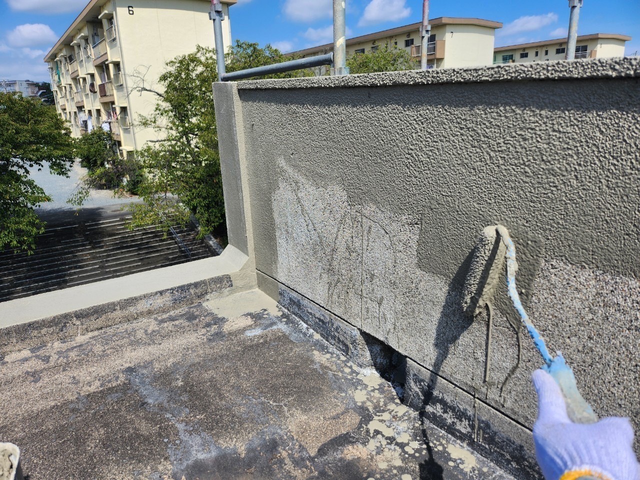 桑名市にて長屋住宅のコンクリート防水経年劣化で雨漏り、ウレタン防水工事で側面にカチオン材にて下地処理を施している所