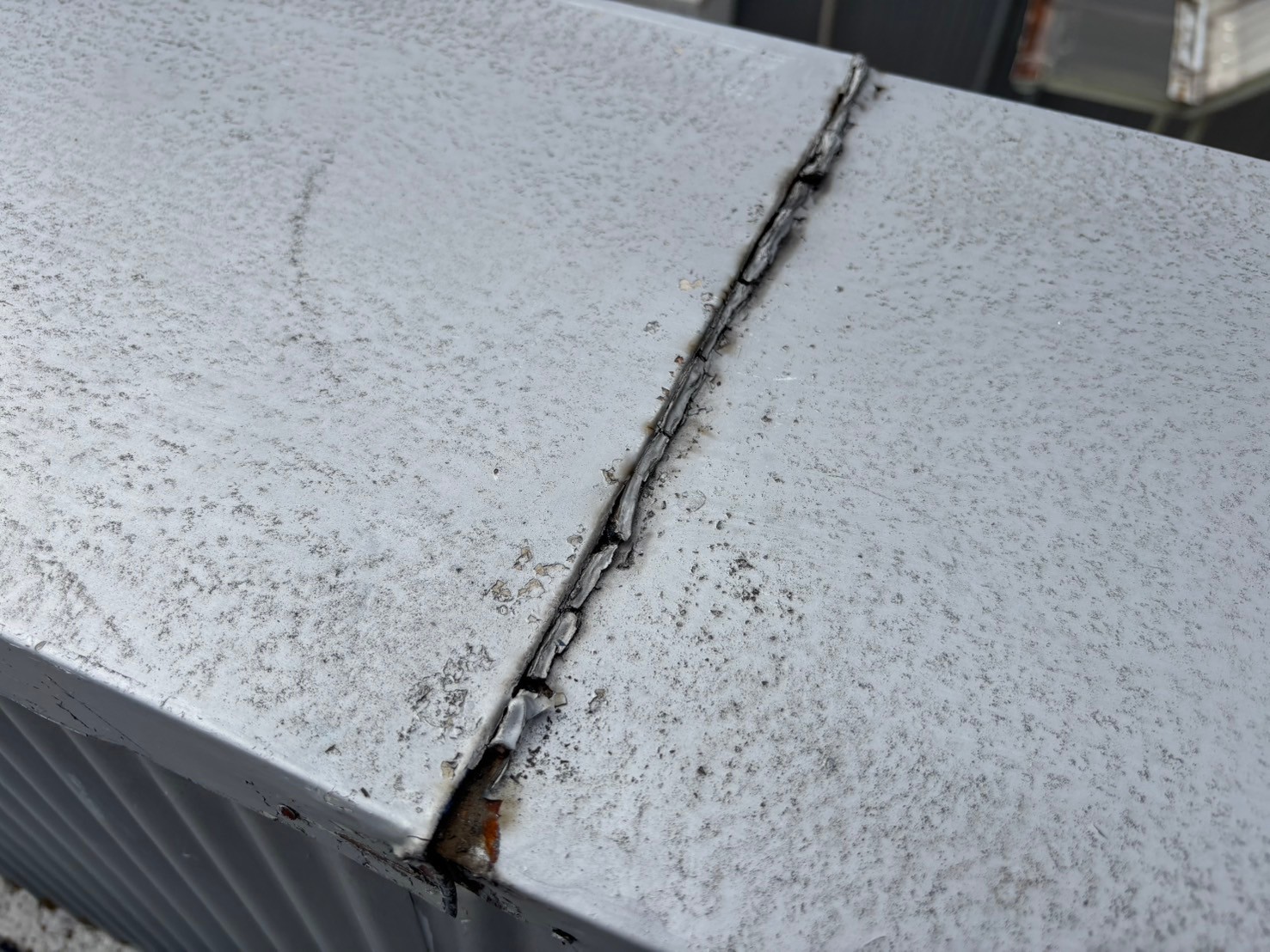 笠木の劣化により雨漏りが発生していた倉庫屋上に、新たに大きめの笠木を被せて雨漏り修理を実施した様子