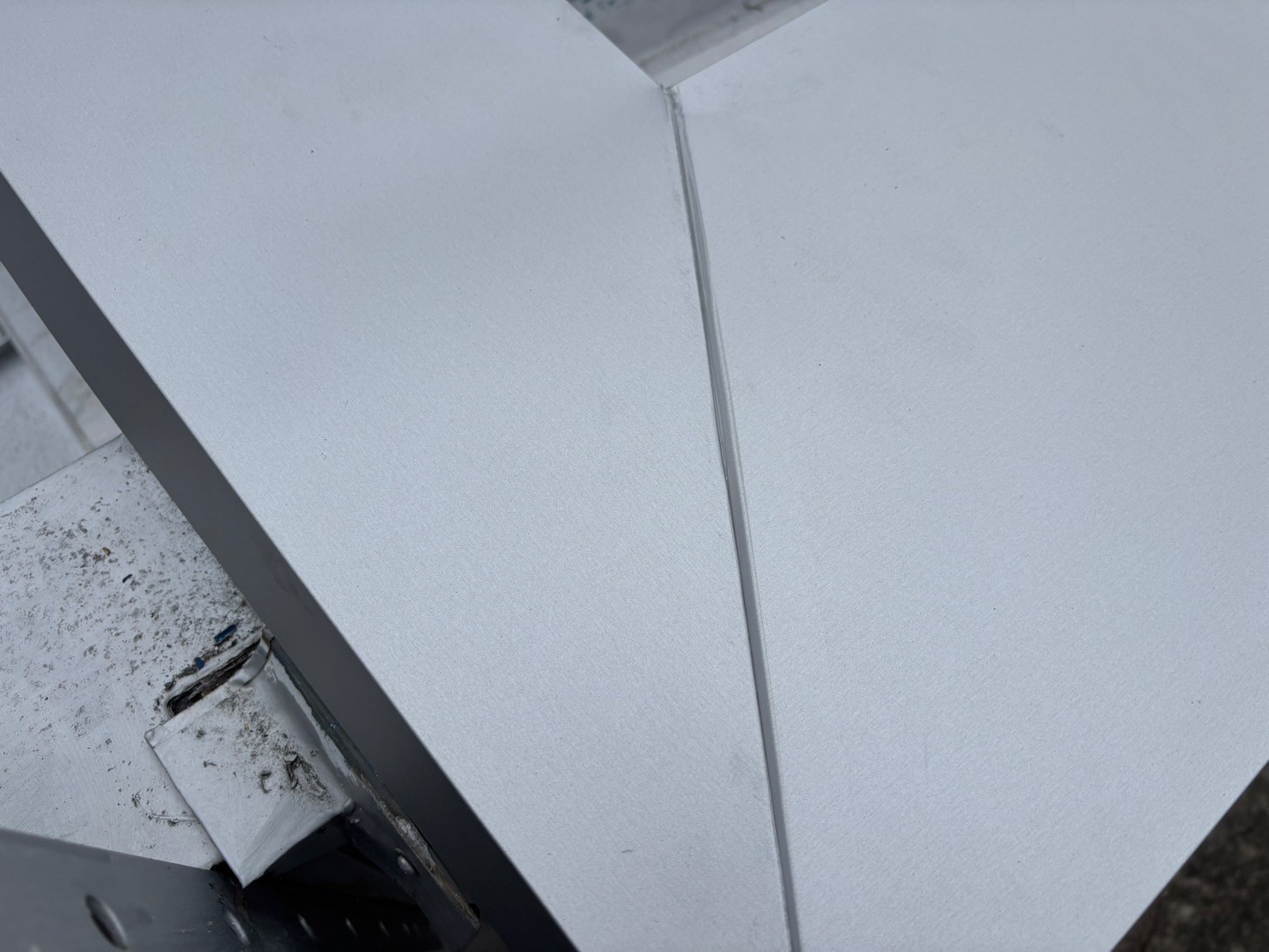 笠木の劣化により雨漏りが発生していた倉庫屋上に、新たに大きめの笠木を被せて雨漏り修理を実施した様子