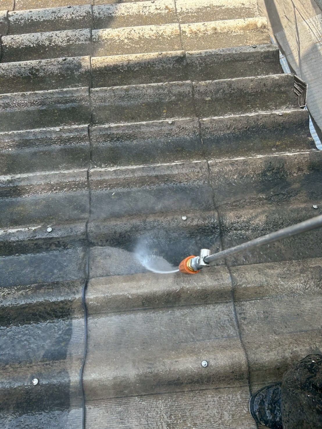 高圧洗浄で外壁の汚れを落としている写真桑名市