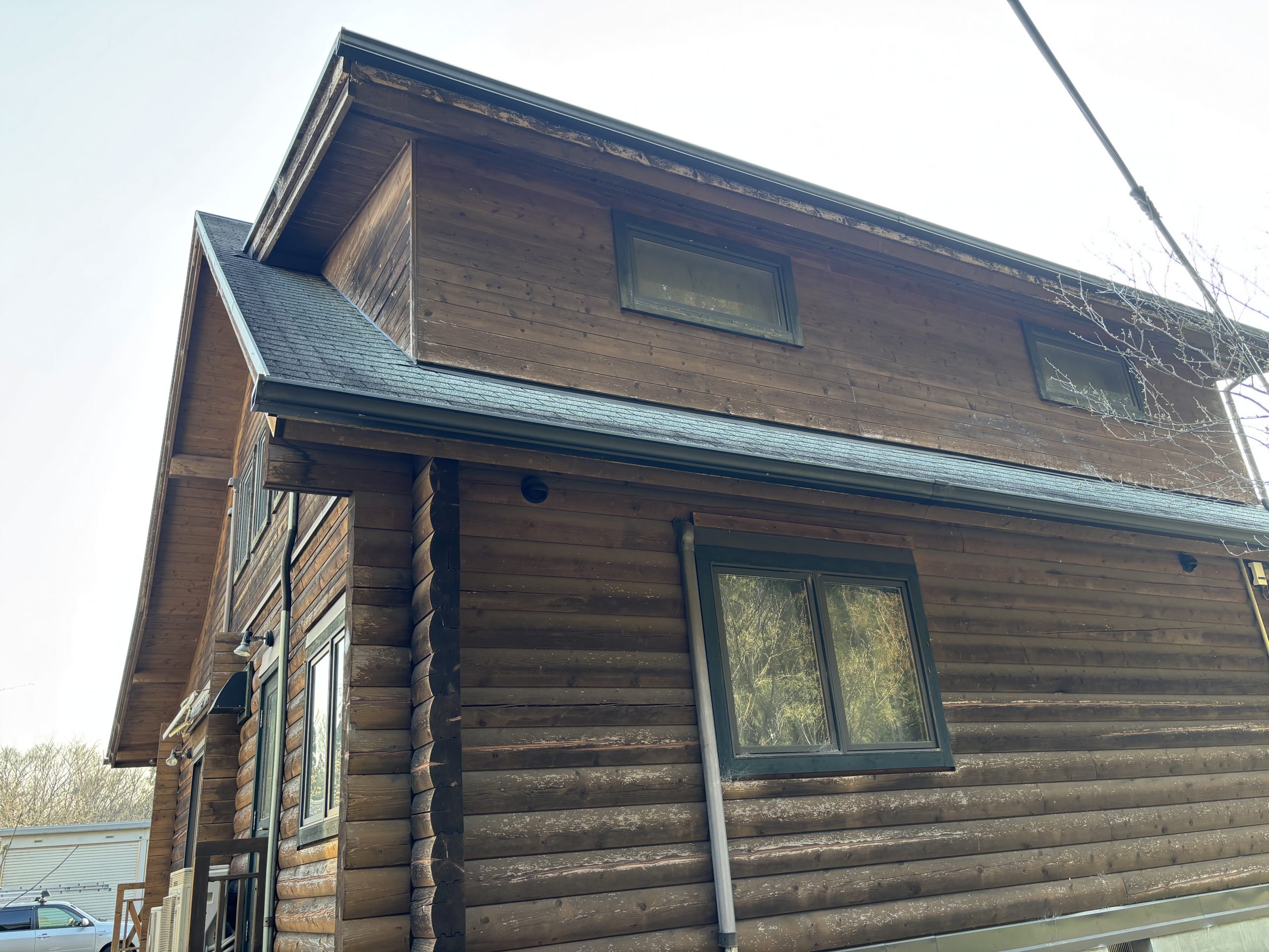 ノンロットで再塗装されたログハウスの外壁とウッドデッキ（いなべ市施工事例）