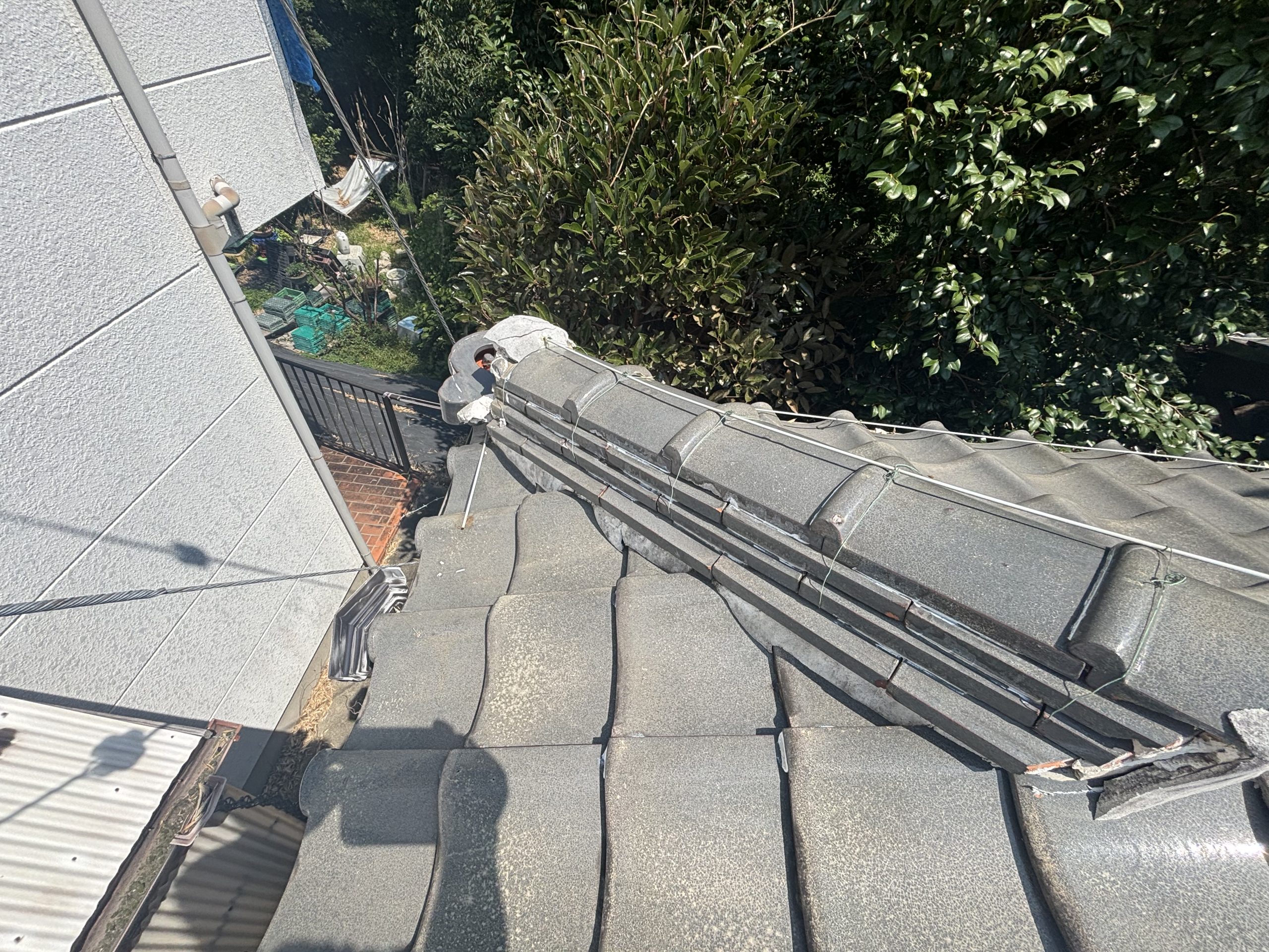 鬼瓦が転倒し固定線が緩んだ棟の状態と周辺ひび割れ四日市市