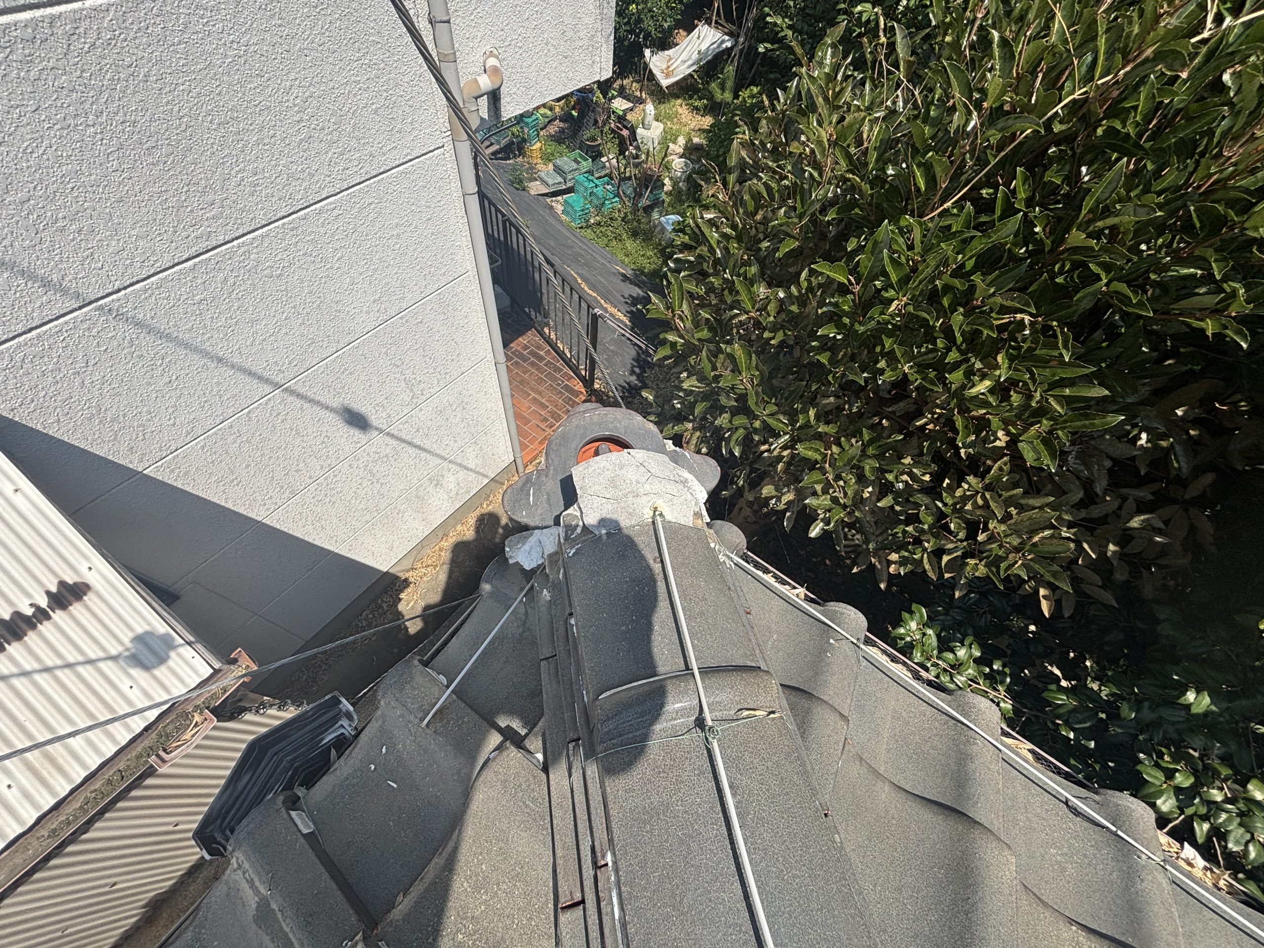 鬼瓦が転倒し固定線が緩んだ棟の状態と周辺ひび割れ四日市市