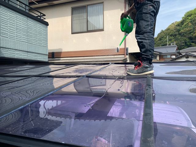 カーポートにジョウロで水を流す