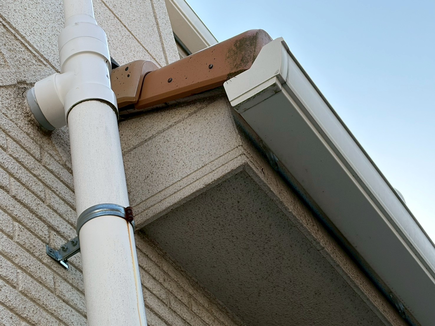 サビ汁が垂れている白い縦樋