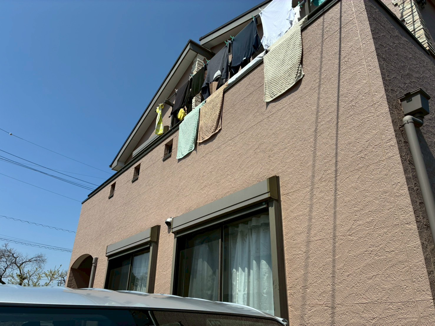 薄いピンクの外壁の建物を見上げる