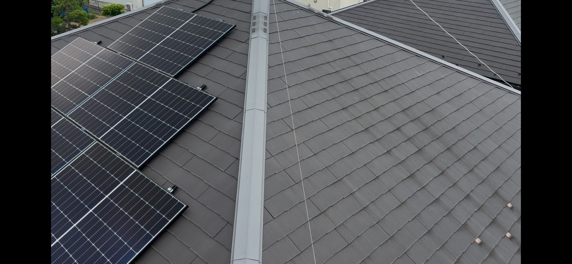 太陽光が載っている黒いスレート屋根