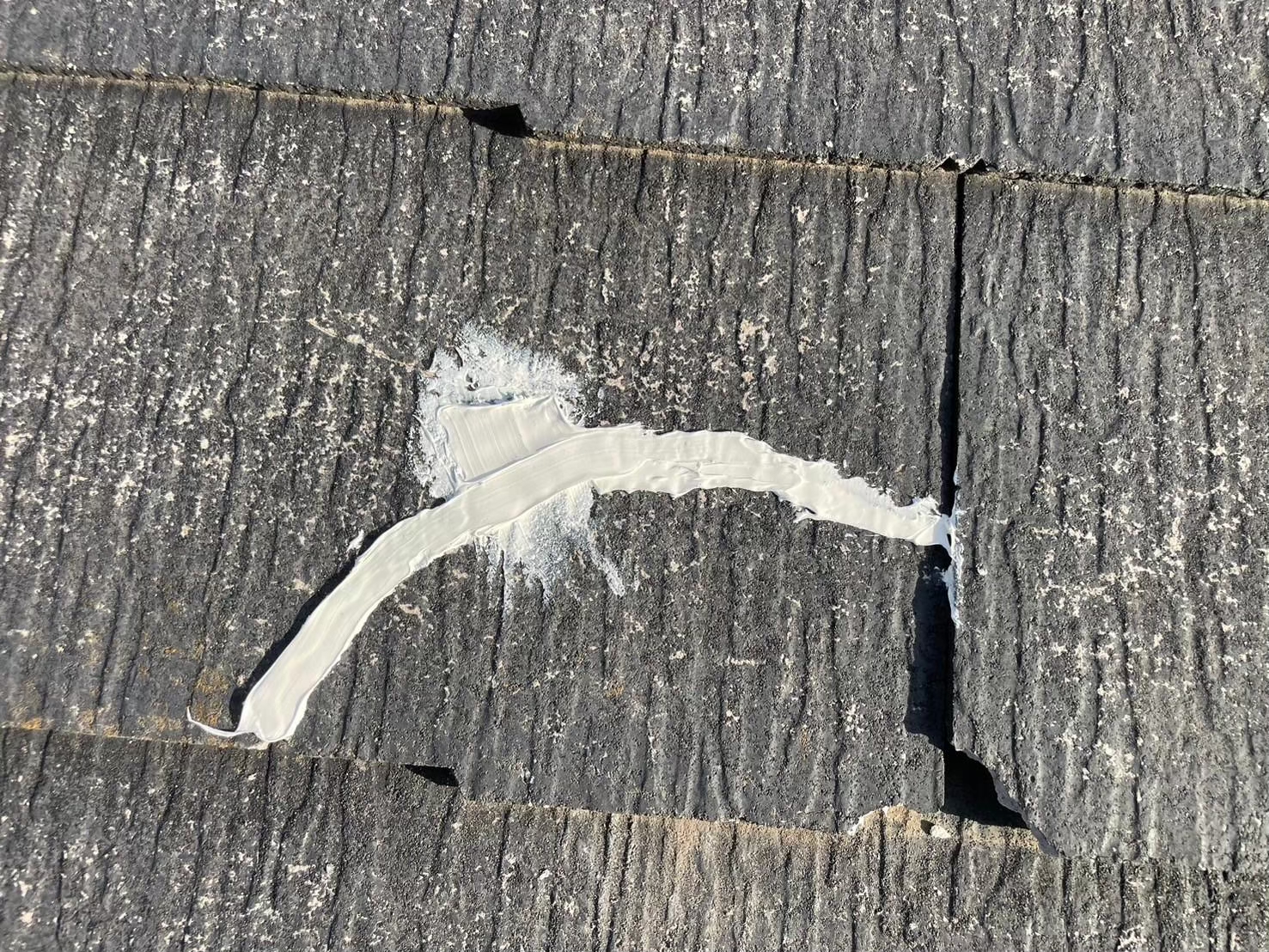 スレート屋根の上からひび割れに補修材を充填