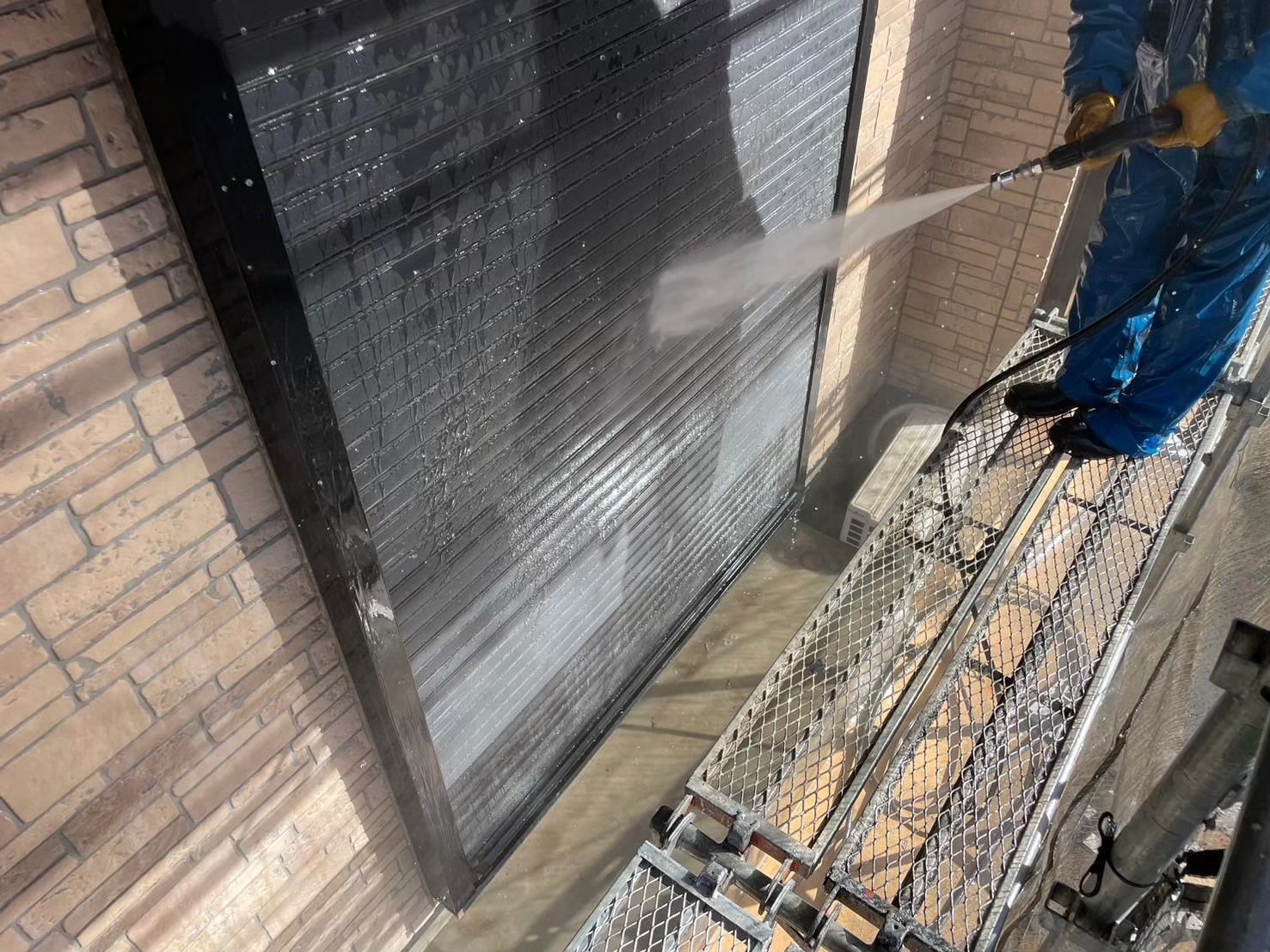 シャッターを高圧洗浄で掃除中