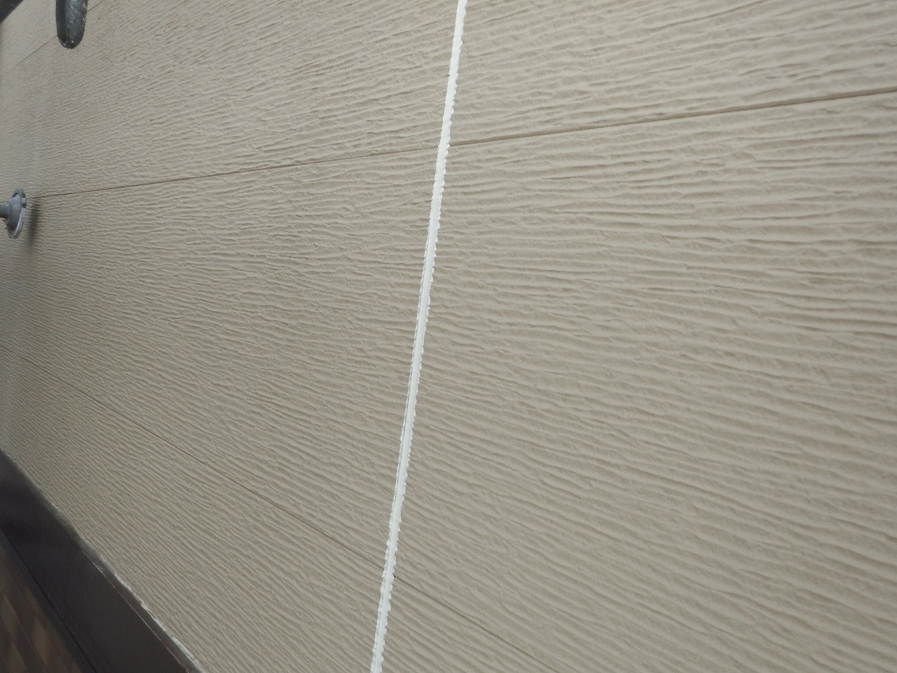 生駒市の屋根塗装現場で外壁のシール打ち