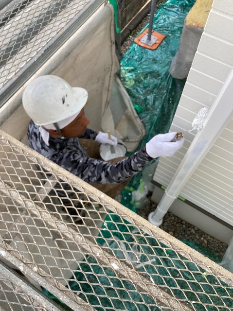 白い外壁に沿って雨樋も白く塗っていきます