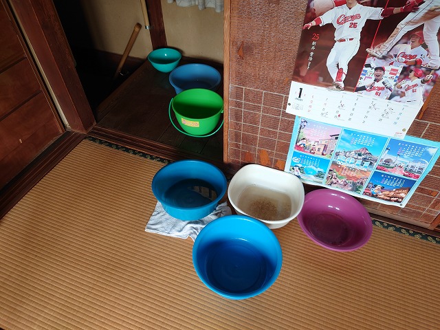 雨漏りしている箇所に置かれたバケツと洗面器