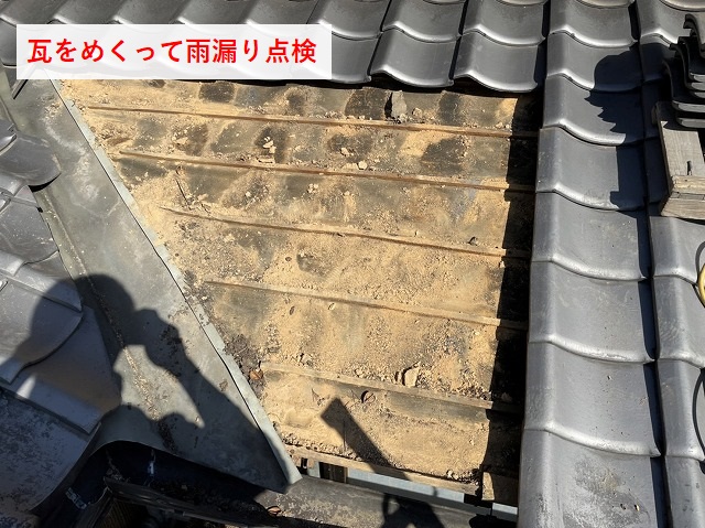 瓦をめくって雨漏り点検している様子