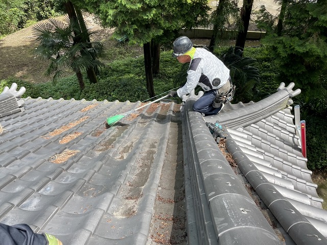 箒を使って屋根掃除