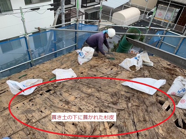 瓦の下の葺き土を掃除している様子