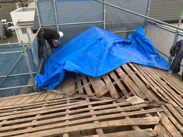 シートをかけて雨養生している写真