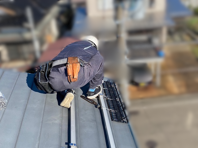 隣地側の屋根面にスノーガードを取り付けている様子