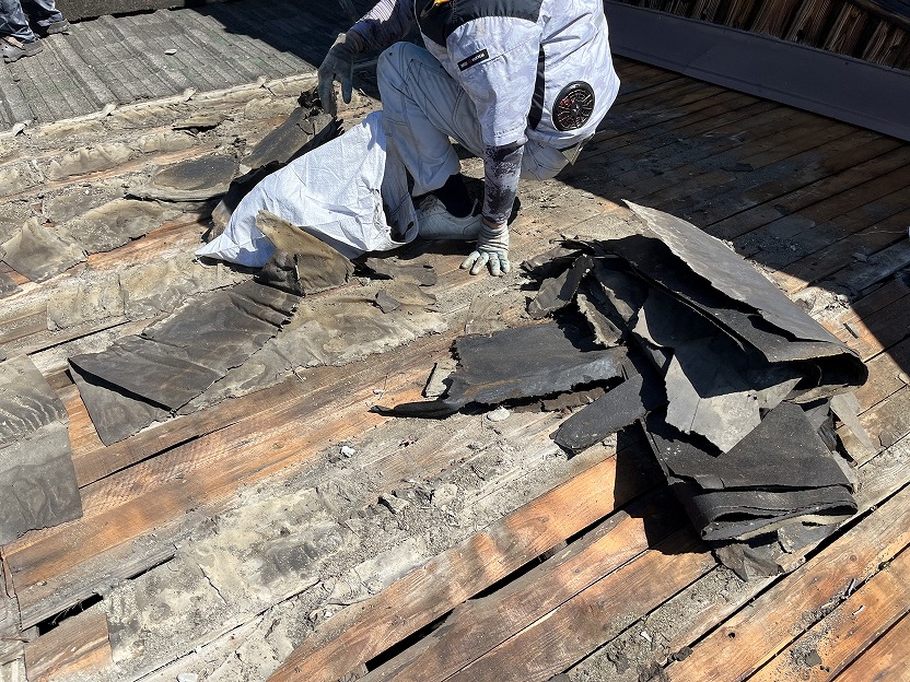 ボロボロになっている防水シートを撤去している様子