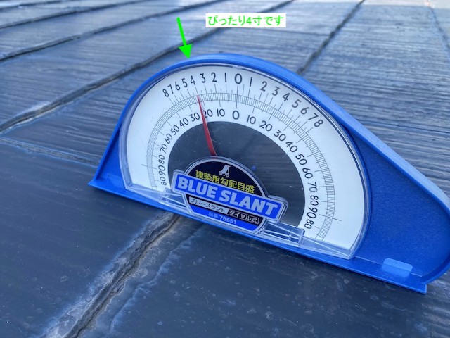 スレート屋根に勾配計をあてる