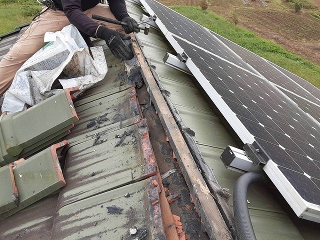 棟瓦を解体する瓦職人