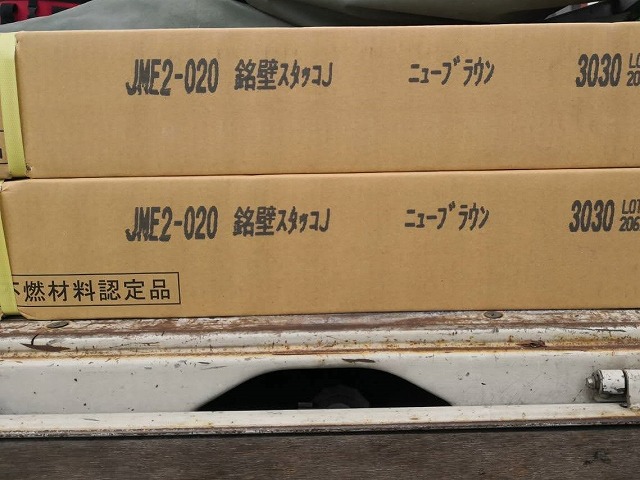 銘壁スタッコJ、ニューブラウンと印字された、梱包された外壁材