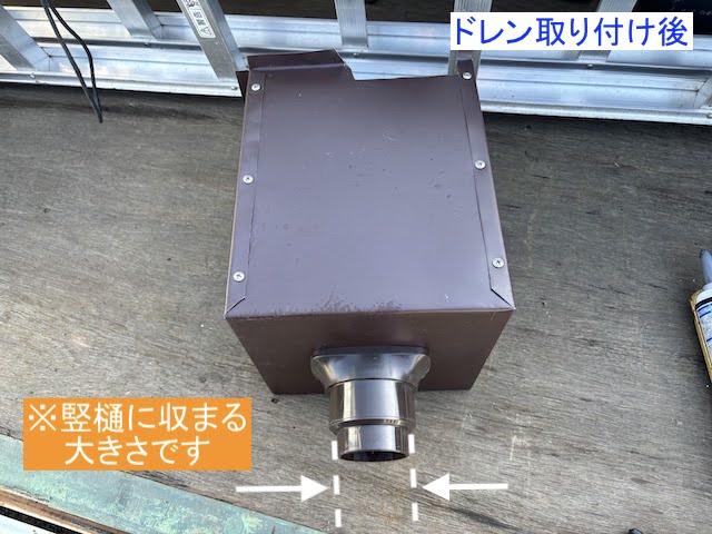 竪樋に納まるドレンが取り付けられた集水器