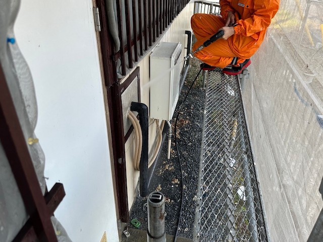 しゃがみながら洗浄を実施するスタッフ