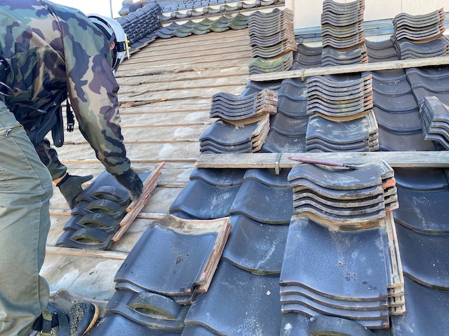 古い瓦を一時的に撤去する職人