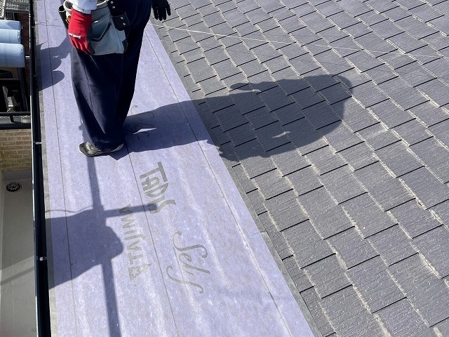 粘着式ルーフィングを足で踏んで密着