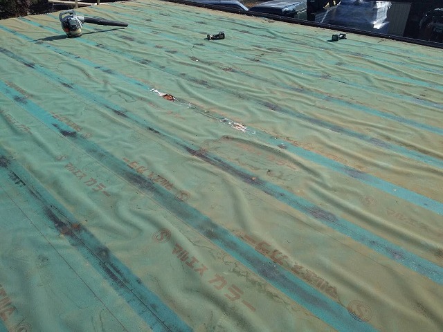既存の屋根材を捲ると、防水シートに広範囲の雨漏り痕が確認できる