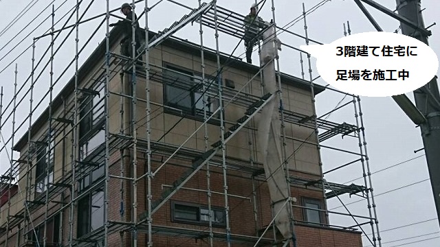 水戸市の3階建て住宅に足場を組む2人の職人