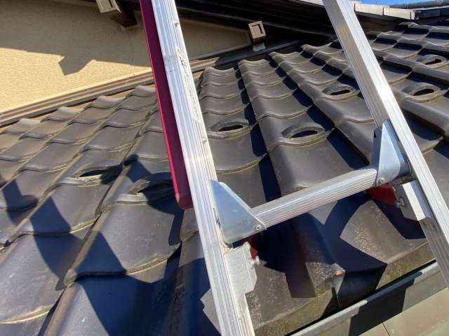 屋根に梯子をかけ登ります