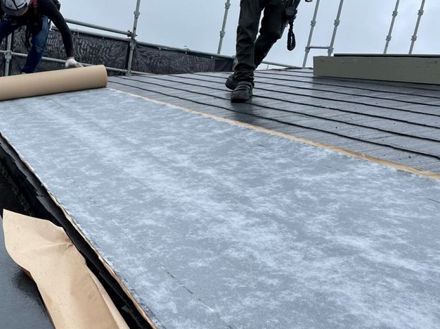 粘着式防水シートをカラーベスト屋根材に施工する職人