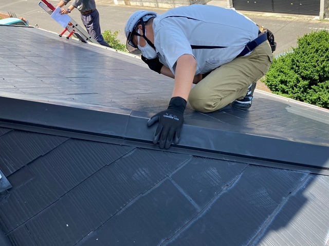 棟板金の釘浮き状態をチェックするスタッフ