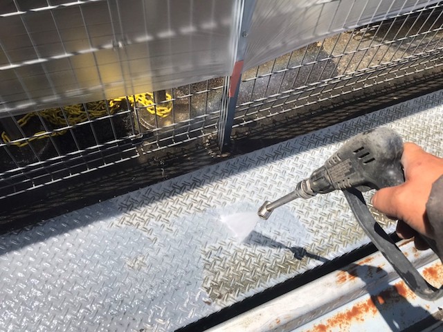 駐車場のステップ部分に高圧洗浄を実施する職人