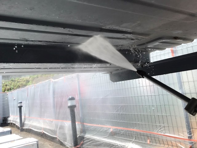 二段式駐車場の裏側を洗浄する職人